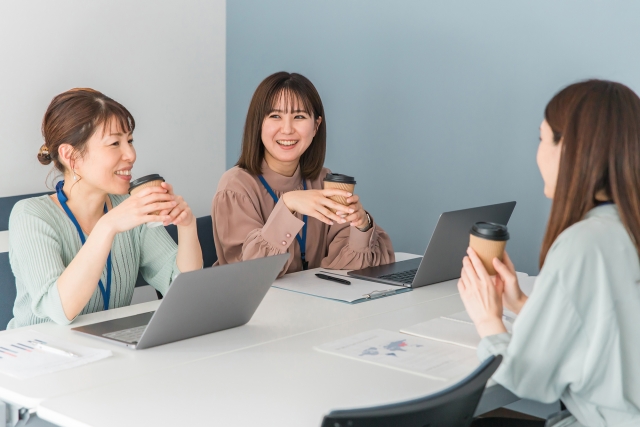 コーヒーを片手にミーティングをしている会社員たち